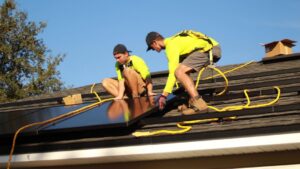 A family standing in their backyard looking at rooftop solar panels on their home.