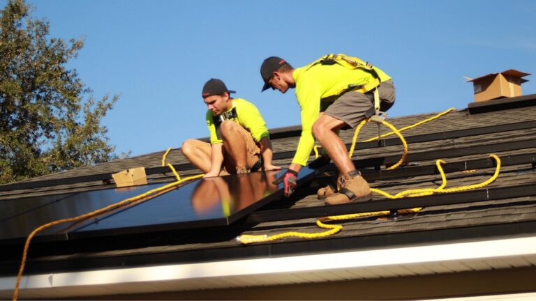 A family standing in their backyard looking at rooftop solar panels on their home.