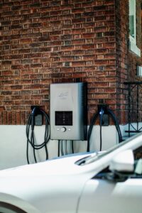 A homeowner reviews a wall-mounted solar battery beside an electrical panel in a garage.