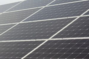 Residents review a community solar agreement beside a utility bill and solar panel display.