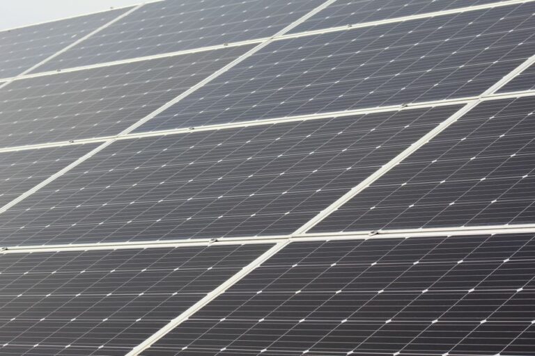Residents review a community solar agreement beside a utility bill and solar panel display.