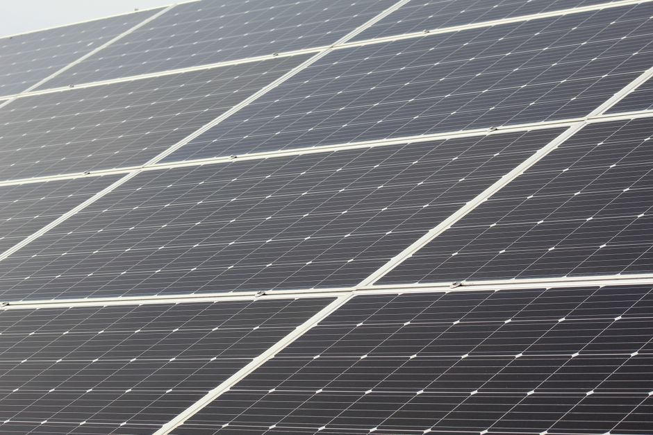 Residents review a community solar agreement beside a utility bill and solar panel display.